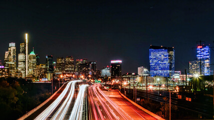 Fototapeta na wymiar Skyline of Philadelphia (PA) USA at night with car trails on a expressway, with copy space.