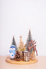 Christmas and New year still life composition fat home interior. Xmas decorations with snowman, deer, Christmas trees
