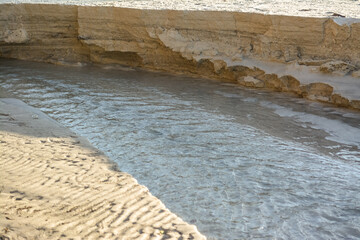 sand crumbling into the water and beach erosion after a storm
