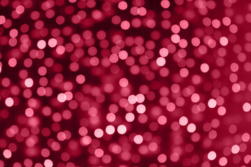 Blurred garland. City night light blur bokeh, defocused background. Abstract pattern. Trending color of 2023 - Viva Magenta.