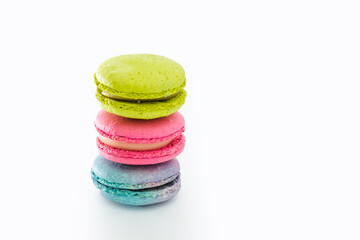 Brightly colored stacked up macarons on white. Tasty colourful macaroons. Blue, pink and green macaroons isolated on white background. French pastry made from egg whites. Concept of food, desserts