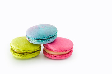 Brightly colored stacked macarons isolated on white background. Tasty colorful macaroon assorted. Three sweet macaroons cakes. French pastry made from egg whites. Culinary and cooking concept.