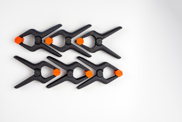 six black plastic photographic and woodworking clamps isolated on a white background