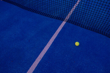 selective focus, a ball on a paddle tennis court at sunset