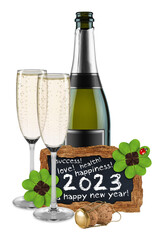 Bottle of champagne with glasses blackboard with happy new year 2023 greetings decorated with four leaf clover and lady bug isolated white background