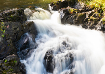 Fototapeta na wymiar Maine stream running over the rocks in a cascade