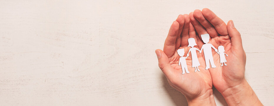 Hands with paper family silhouette. Family care