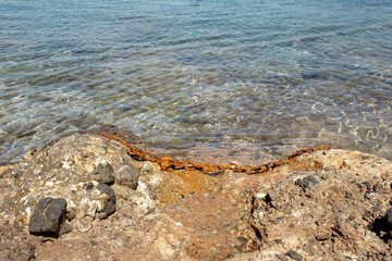 Landscape of a seashore with a rusty chain.