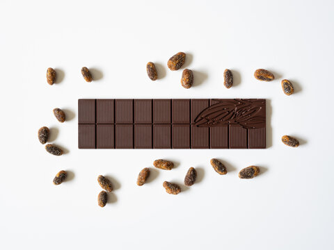 Une tablette de chocolat noir et des f&egrave;ves de cacao grill&eacute;es.
