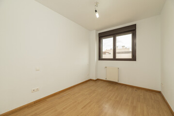 Room of a house for sale with floating oak flooring, white aluminum radiators and brown anodized aluminum window