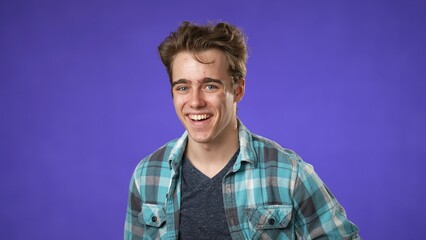 Portrait of smiling happy young hipster man 20s isolated on solid purple background with copy space in studio
