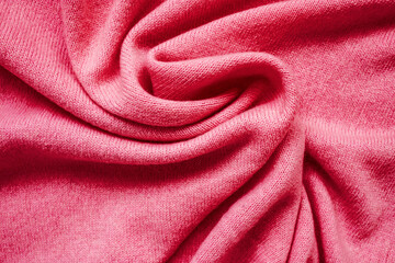 Fototapeta na wymiar The texture of the pink cashmere sweater. Top view, close-up. Сolor Viva Magenta. Demonstrating the colors of 2023.