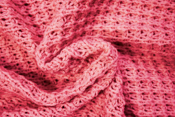 The texture of the knitted woolen thread in close-up. Сolor Viva Magenta. Demonstrating the colors of 2023.