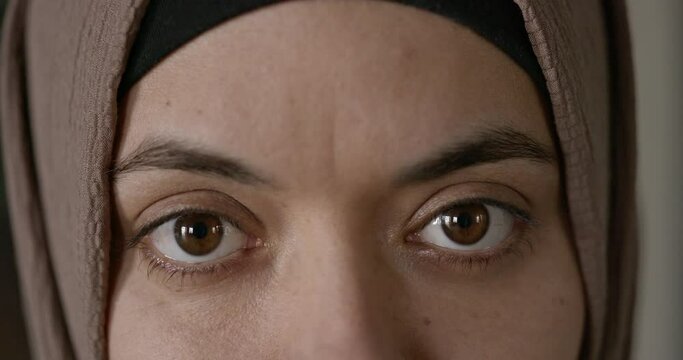 Close-up eyes of woman in hijab looking at camera