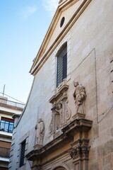 Fototapeta na wymiar Baroque facade of the Catholic church of San Miguel in Murcia, with sculptures of saints 