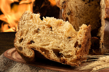 Sliced panettone on wood with blurred fire background