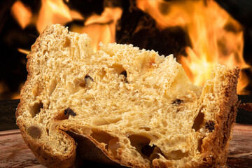 Sliced panettone on wood with blurred fire background