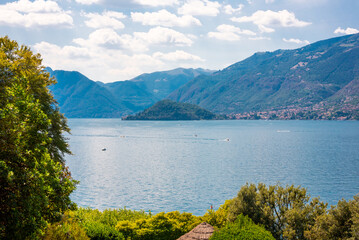 Fototapeta na wymiar Lake Como in Italy. Natural landscape with trees and mountains by lake
