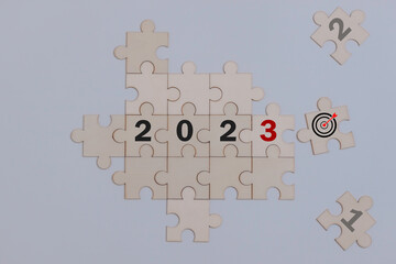 Numbers 2023 using jigsaw and red puzzle at last one with linked pieces. Lets meet together challenges of Happy New Year 2023. Inspiration, goal, target and greeting card motivator concept.