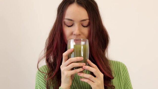 The morning, the drink and the concept of people. A young woman with a cup of matcha tea. Beautiful girl enjoying about to drink a detox drink to lose weight