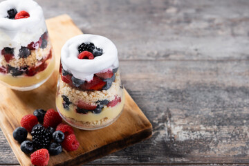 Trifle dessert with berries and cream on wooden table.typical english dessert