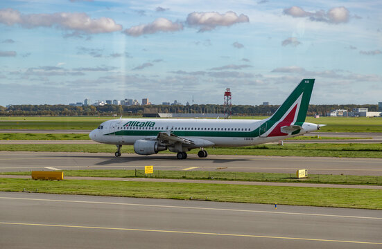 Amsterdam, Netherlands - October 19, 2022: A picture of an Airbus A320 Alitalia plane on the runway.