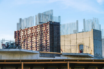 The foundation on reinforced concrete piles and the frame during the construction of a multi-storey building. Reinforcement of reinforced concrete columns. Construction of high-rise buildings.