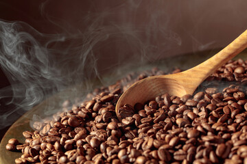 Coffee beans are smoky in a roasting pan.