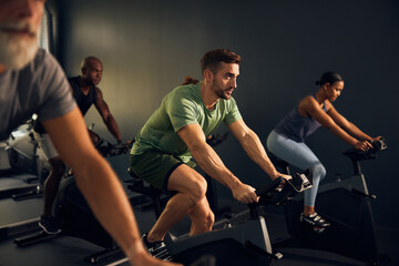 Fit man in a gym cycling class