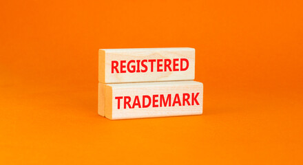 Registered trademark symbol. Concept word Registered trademark on wooden blocks. Beautiful orange table orange background. Business and registered trademark concept. Copy space.