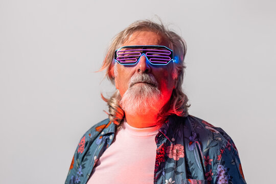 Senior male in led rave glasses in studio