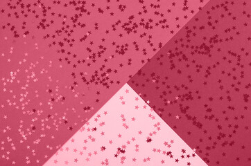 Beautiful festive abstract magenta background with metallic star shaped confetti. Color trend year 2023.