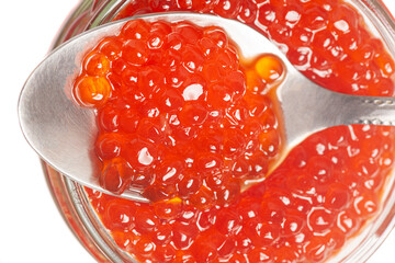 Glass jar and spoon with delicious red caviar isolated on white background.