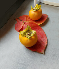 Sweet orange ripe persimmon fruits on the table in the autumn morning. - 550905748