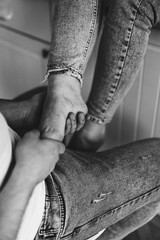 Male hands massage the foot of a pregnant woman. Black and white photo. advertisement of massage salt