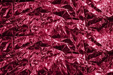 Photo of crumpled foil texture in trendy viva magenta color