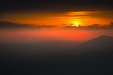 Fototapeta na wymiar Beautiful sunset above mountains; the forest at orange sunset