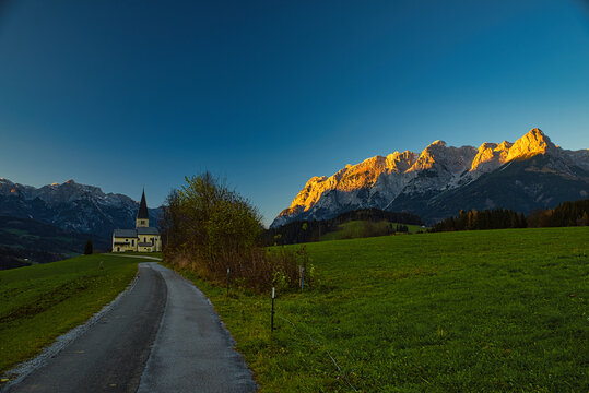 das tennengebirge mit buchbergkirche im Vordergrund  im Sonnenuntergang Alpengl&uuml;hen vom Buchbergaus gesehen Bischofshofen Pongau Salzburg 