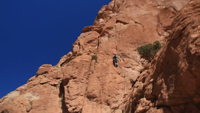 Climbers climb a rock wall. Todra Gorge, Atlas, Maroc, Africa.