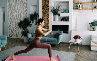 Slim woman doing yoga in spacious living room