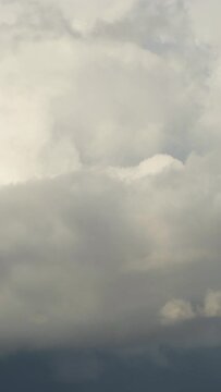 Rain clouds forming in a blue sky. Time Lapse. 4K Vertical