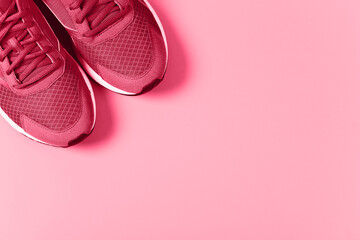 Sneakers on red background. Concept of healthy lifestile and food, everyday training and force of will. Demonstrating Viva Magenta - trendy color of the year 2023 - 550913593