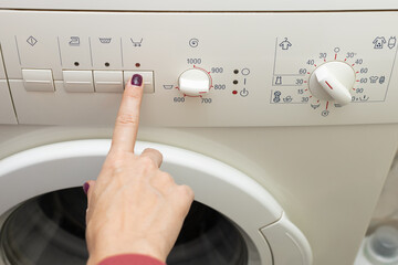 A person chooses a washing mode with a switch.