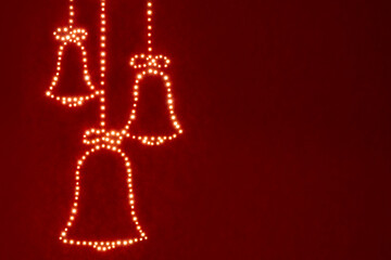 concept greeting card of Christmas bells with mystical miracle light on red background, beautiful...