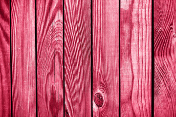 Light red wood plank wall texture background. Demonstrating Viva Magenta - trendy color of the year 2023