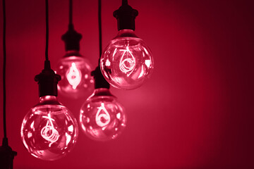 Group of red lamps with interesting shape of tungsten filament. Demonstrating Viva Magenta - trendy color of the year 2023