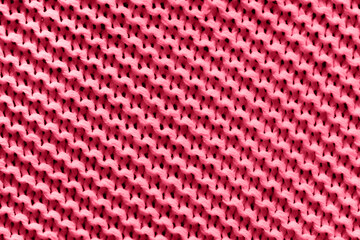 Red knitted texture macro. Perfect diagonal composition. Demonstrating Viva Magenta - trendy color of the year 2023