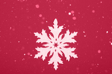 Snowflake with silver glitter on red background. Demonstrating Viva Magenta - trendy color of the year 2023