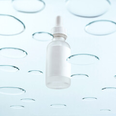 a bottle with a pipette for cosmetics on a background with drops