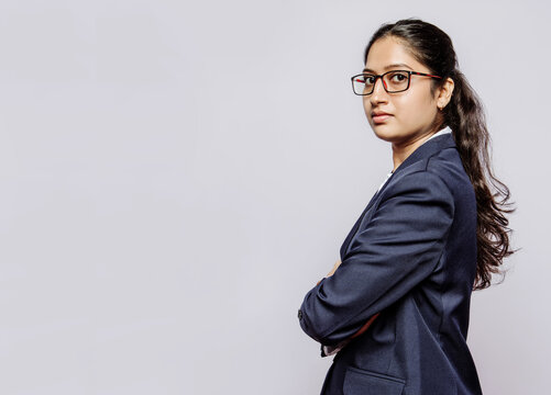 Side view of a college girl in blue suit hands folded and specs